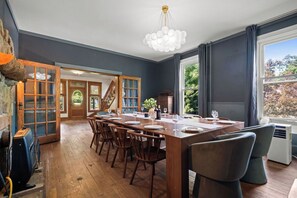 Comedor con una mesa de madera dispuesta para seis comensales, un candelabro y vistas al exterior.