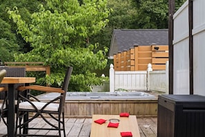 A patio with outdoor furniture, a hot tub, and a wooden fence. - Spacious 6-bedroom house in peaceful Fayetteville (Fayetteville)