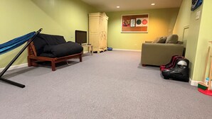 Une pièce comprenant un lit superposé, un canapé, une armoire et un mur décoré d’œuvres d’art.