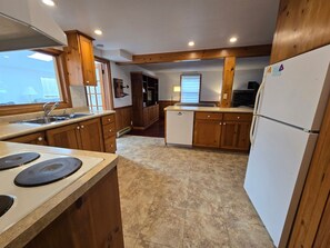 A kitchen with wooden cabinets, a built-in oven, a sink, and a refrigerator. - Lakefront Cottage in the Heart of Kincardine | 3 BR | 2 Baths | 2 Decks (Kincardine)