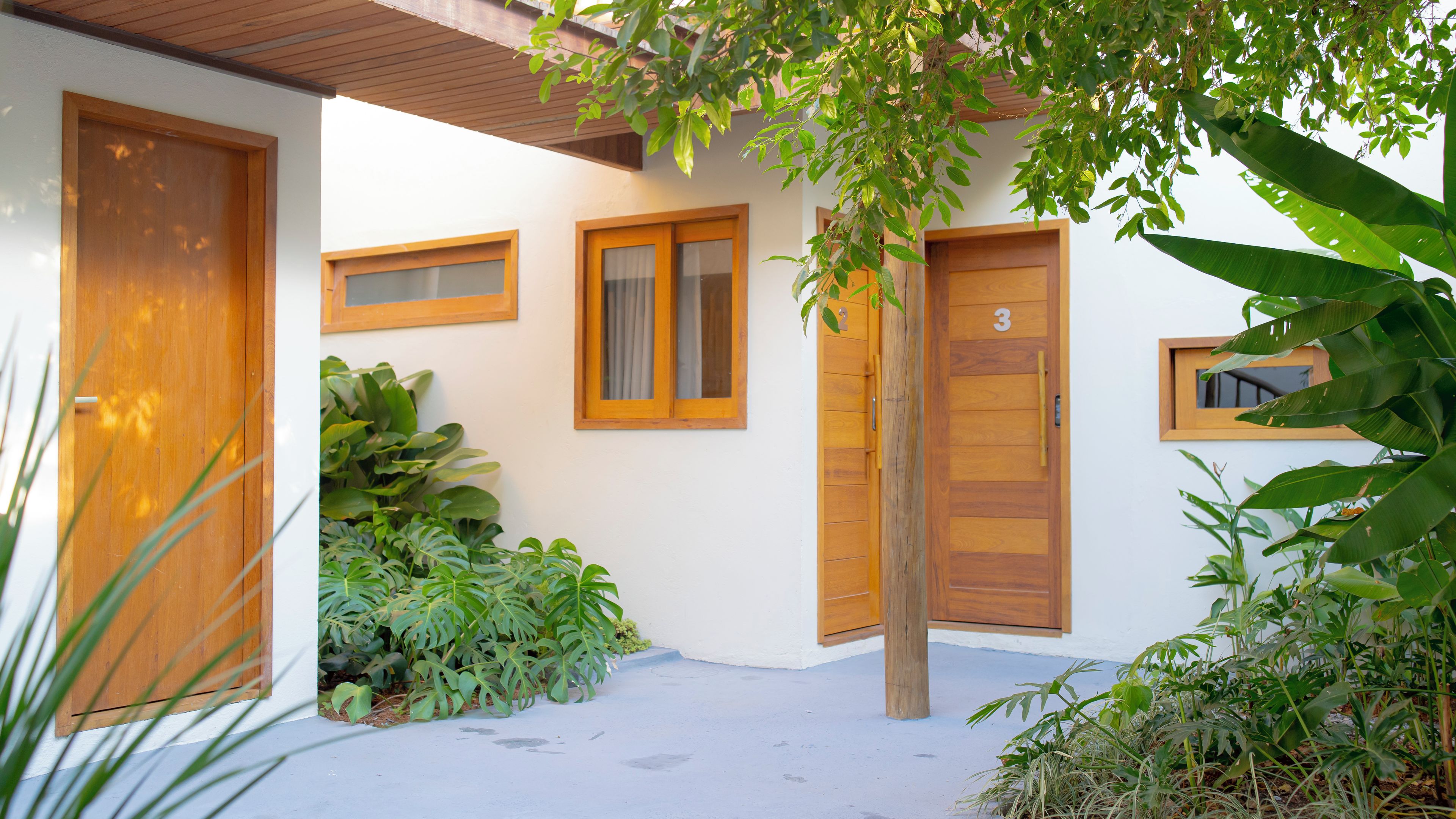 A building with a white exterior, wooden doors, and windows. There is a number '3' on one of the doors.