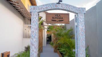Uma placa de madeira com a inscrição 'VILA ROMANA', indicando o nome do local.