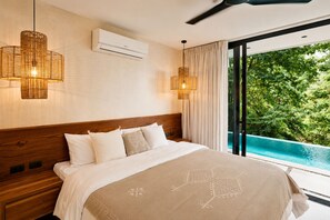 A bedroom with a large bed, an air conditioning unit, and a view of a swimming pool. - Panoramic Ocean Views • Eco-Luxury Solar Retreat with 5 bedrooms (Santa Teresa)