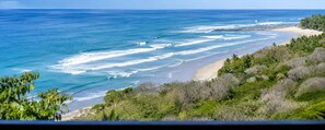 A coastal landscape with a beach, ocean, and vegetation. - Panoramic Ocean Views • Eco-Luxury Solar Retreat with 5 bedrooms (Santa Teresa)