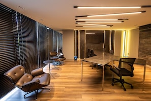 A modern conference room with a long table, leather chairs, and a wooden floor. - Unigreen Residence Manaira by Carpediem Close to the Beach, Manaira Shopping and MAG Shopping (João Pessoa)