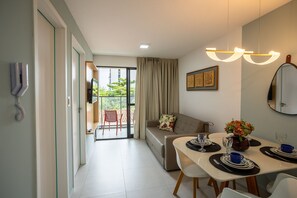 A modern living room with a sofa, dining table, and a view to an outdoor balcony. - Unigreen Residence Manaira by Carpediem Close to the Beach, Manaira Shopping and MAG Shopping (João Pessoa)