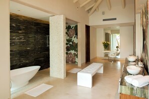A modern bathroom with a large bathtub, a vanity with two sinks, a bench, and a decorative wall with a floral mural. - Gorgeous 5-bedroom house in Puerto Vallarta with fitness room (PUERTO VALLARTA)