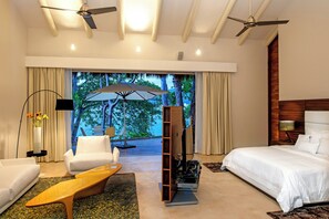 A hotel room with a bed, a sofa, a coffee table, a TV, and a view of the outdoors. - Gorgeous 5-bedroom house in Puerto Vallarta with fitness room (PUERTO VALLARTA)