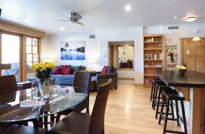 Un espace de vie moderne comprenant une table à manger, des canapés et un bar de cuisine.