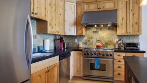 A kitchen with wooden cabinets, a stainless steel refrigerator, a stove, and a dishwasher. - Modern Elkhorn Updated 2 bedroom/2 bath (Sun Valley)