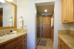Une salle de bain avec un lavabo, un miroir et des meubles en bois.