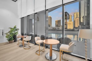 A modern interior with a large window, a round table, and chairs. - Modern 2BR Miami | Rooftop Pool | Near Bayfront (Miami)