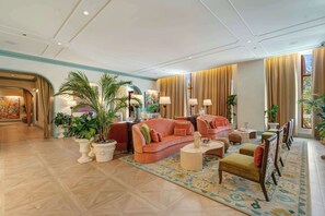 A spacious lobby with a large sofa, armchairs, a coffee table, and potted plants. - Modern Wynwood Studio | Rooftop Pool & Gym Access (Miami)