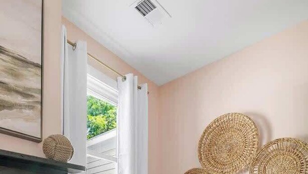 A room with a fireplace, two white chairs, a small table with a plant, and woven wall decorations. - 1880s Charleston Single. Bermuda Suite one bedroom (Charleston)