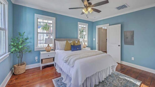 A bedroom with a bed, nightstands, a ceiling fan, and a window with a view. - 1880's Charleston Single. One Bedroom with parking (Charleston)