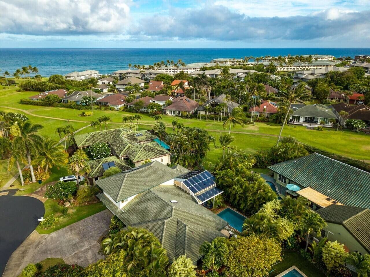 Un quartier résidentiel avec des maisons, une piscine et une vue sur l’océan.