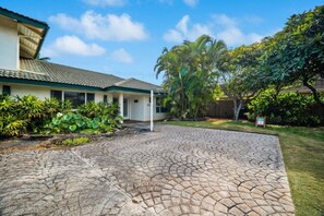 A house with a paved driveway, surrounded by lush greenery and palm trees. - Double Studio Suites with Private Pool and AC, walk to Beach (Koloa)