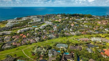 Un quartier résidentiel avec des maisons, des espaces verts et une vue sur l’océan.