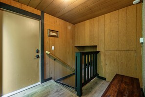 Een houten interieur met een trap, een deur en een klein plankje.
