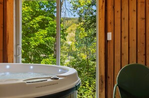 A hot tub with a view of a forested hillside. - Schweitzer Mtn. Retreat -Chalet 75-w/Hot Tub Room + Lift Pass (Sandpoint)
