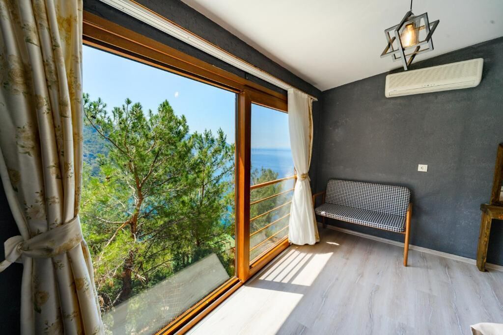 Ein Zimmer mit einer großen Schiebeglasdoor, einer Bank und einem Deckenventilator.