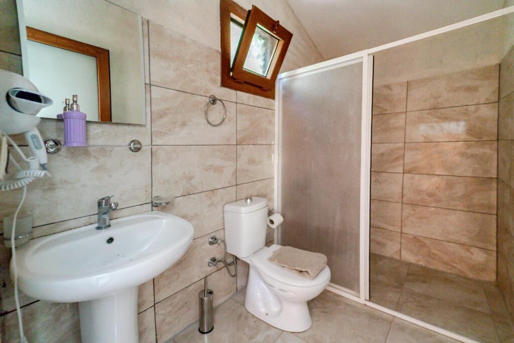 A bathroom with a sink, toilet, and shower.