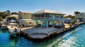 A waterfront property with a dock, a covered outdoor seating area, and a pool. - Waterfront Hideaway · 100-Ft Dock · Hot Tub with TV — Your Keys Escape (Key Largo)