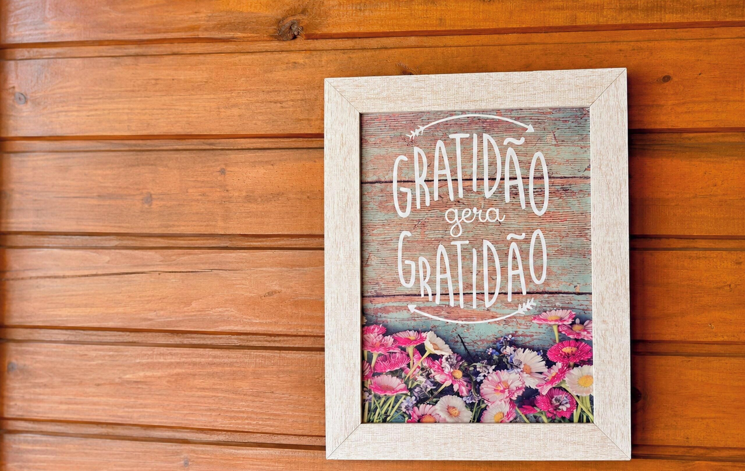 Een lijst met een bord waarop staat 'GRATIDÃO gera GRATIDÃO' tegen een houten achtergrond.