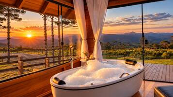 A hot tub with a view of a sunset and mountains.