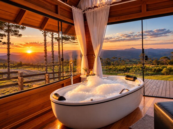 Un jacuzzi con vistas a la puesta de sol y montañas.