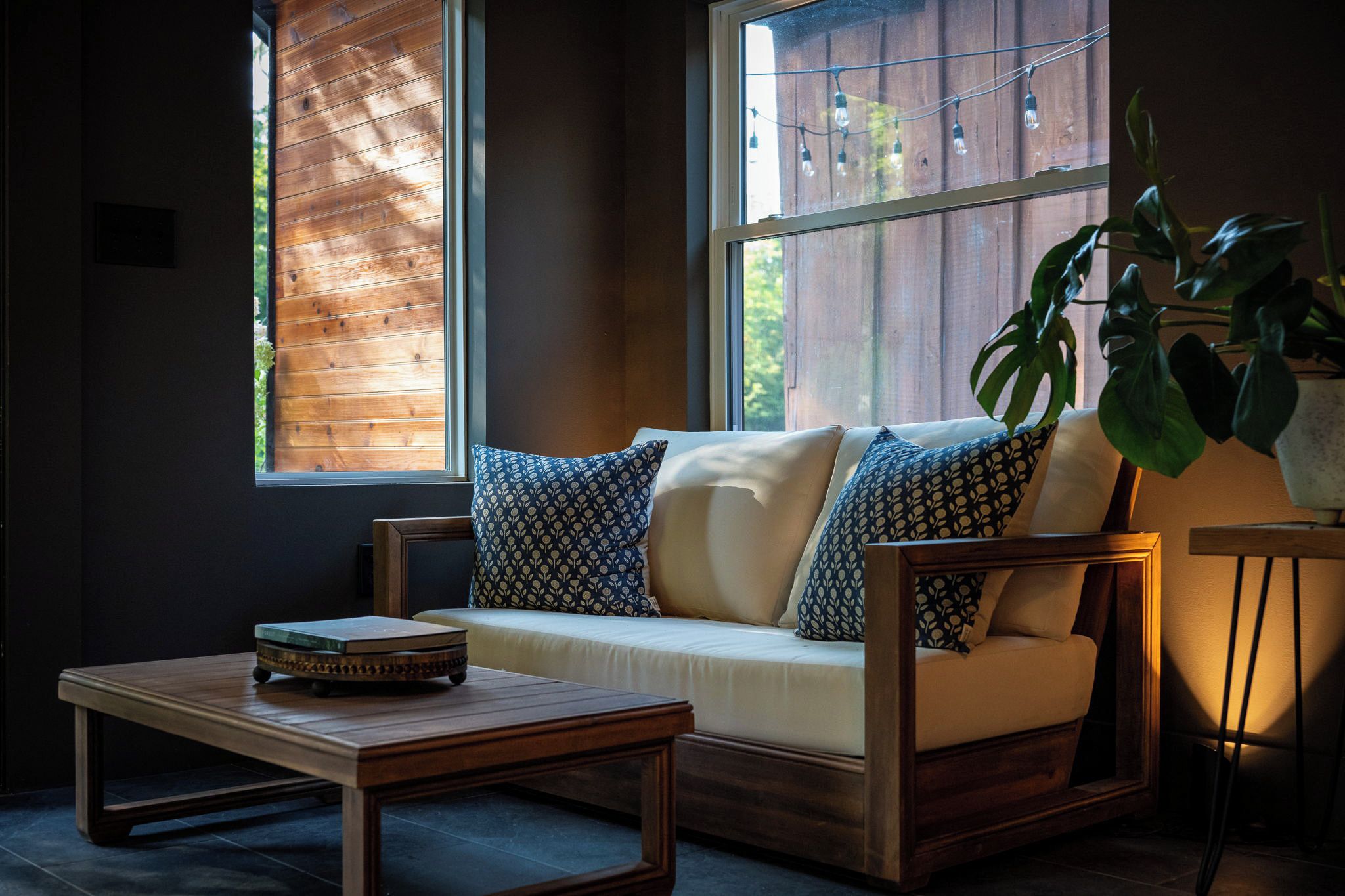 A cozy seating area with a sofa and armchairs, a small table, and a potted plant.