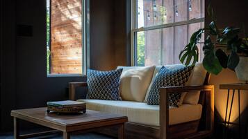 A cozy seating area with a sofa and armchairs, a small table, and a potted plant.