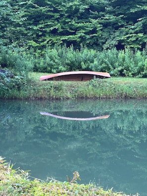 A calm body of water with a wooden bridge and dense greenery in the background. - Storybook Forest Cottage w/Loft, Hot Tub + Sauna Access by Blue Ridge Parkway (Newland)