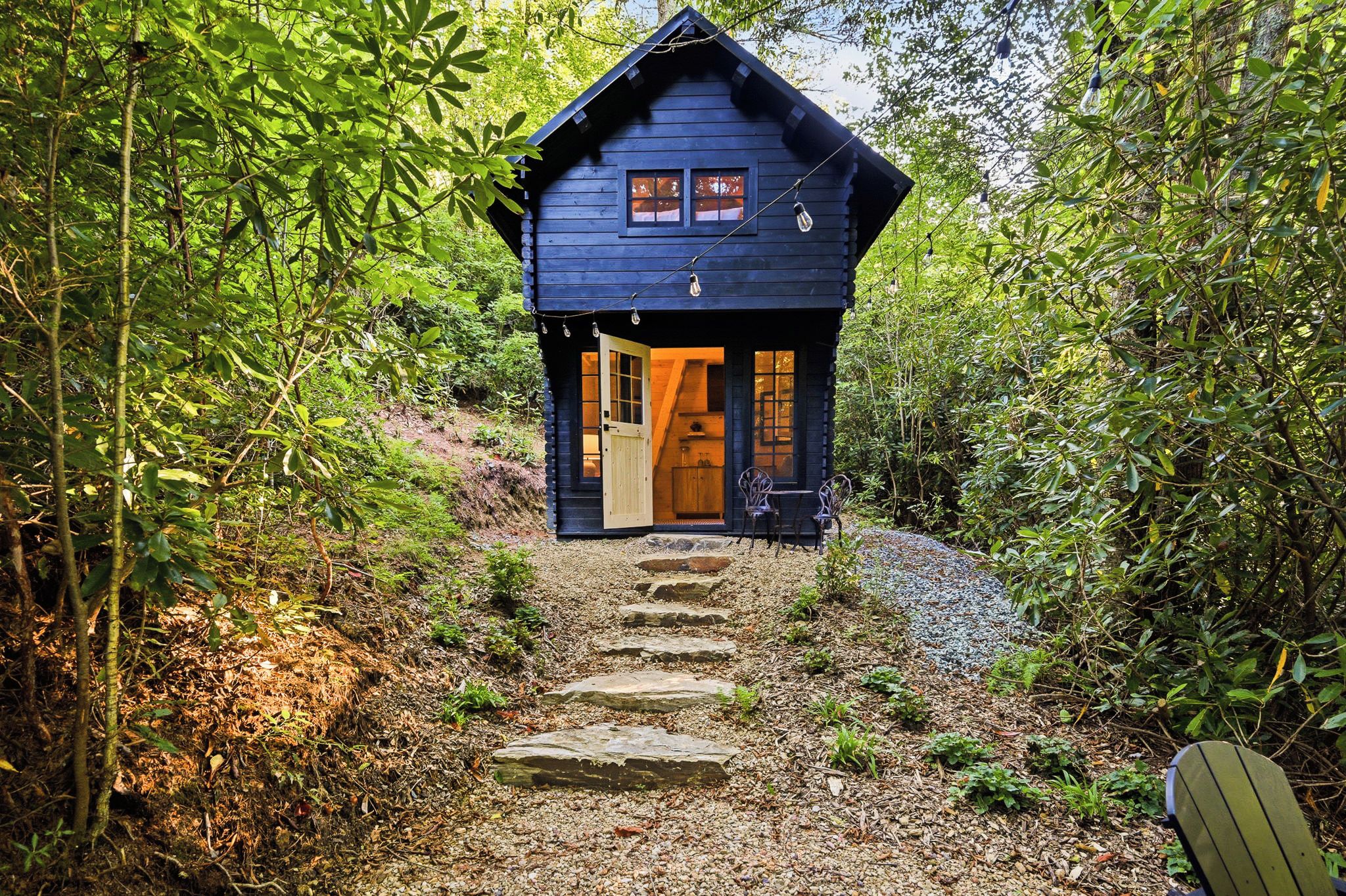 A wooden cabin with a porch, a door, and a window.