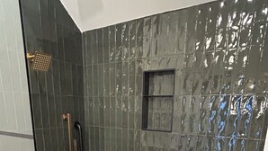 A shower with a glass door, a handrail, and a pebble-patterned floor. - Storybook Forest Cottage w/Loft, Hot Tub + Sauna Access by Blue Ridge Parkway (Newland)