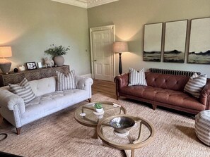 Ein Wohnzimmer mit zwei Sofas, einem Couchtisch und einer Lampe.