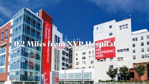 A modern building with a prominent red banner and a glass facade. - Modern 1-Bedroom Apartment with AC in Flushing (FLUSHING)
