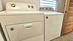 A front-loading washer and dryer unit with control knobs, a door handle, and a brand logo.