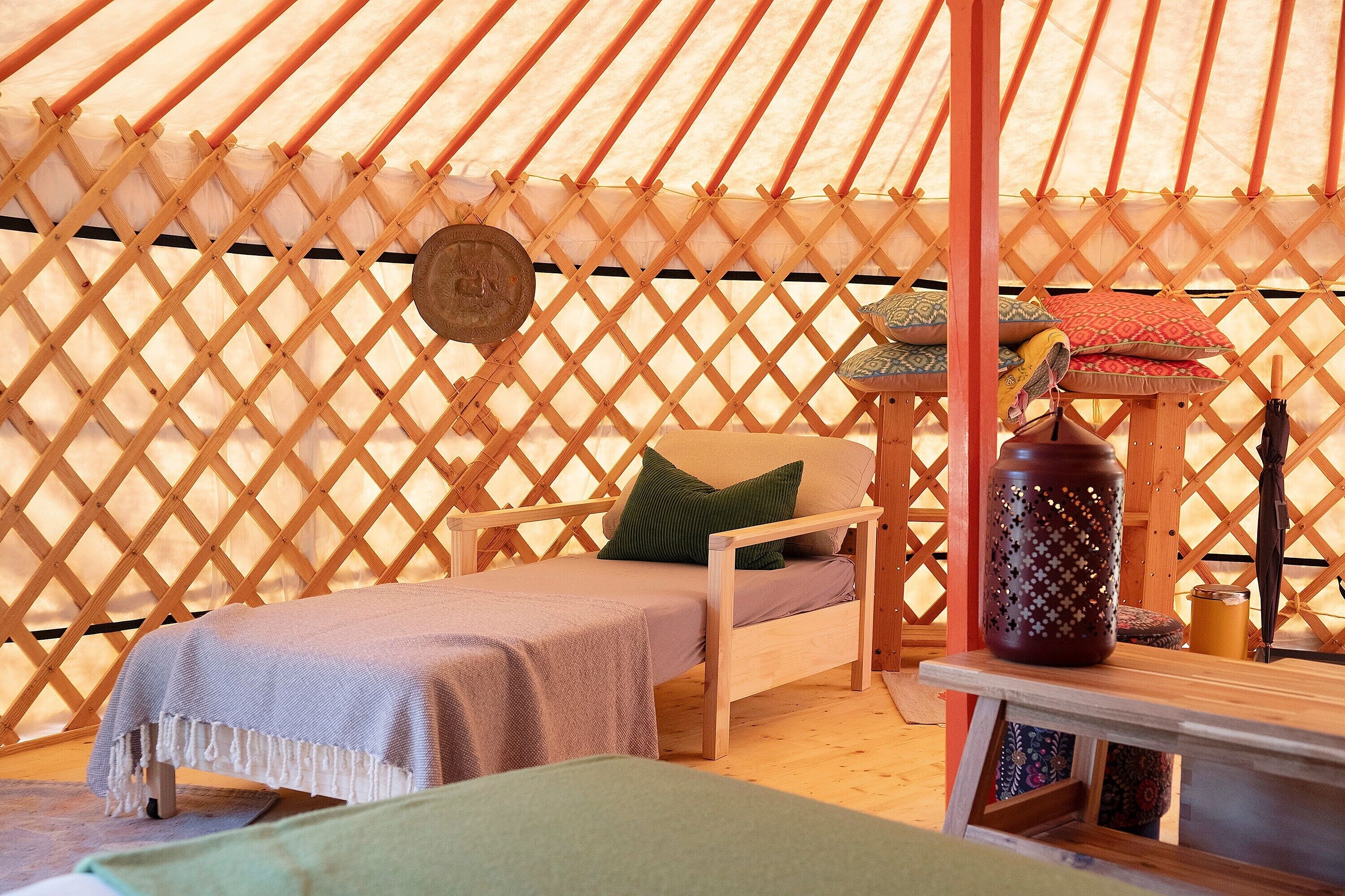 Un interior acogedor con una cama, una mesita y un jarrón decorativo.