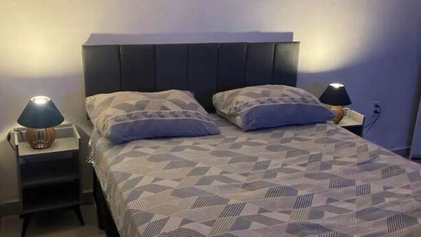 Et soveværelse med en seng, to sengeborde og lamper.