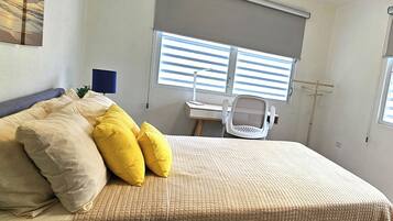 Un dormitorio con una cama, un escritorio y una silla.