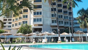 A hotel with a pool area, palm trees, and a clear blue sky. - Hotel Tibisay Maracaibo (Maracaibo)