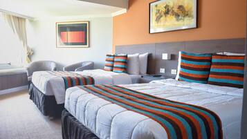 A hotel room with two beds, a desk, a chair, and a painting on the wall.