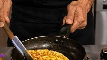 A person cooking an omelette in a pan on a stove.