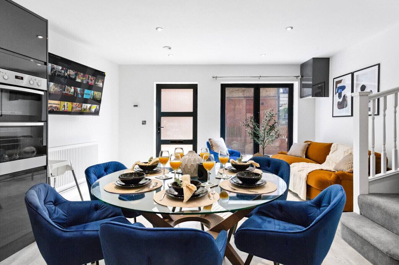 A modern living space with a dining area, kitchen, and seating area.