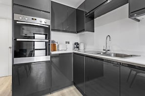 Eine moderne Küche mit Backofen, Spüle und Kaffeemaschine.
