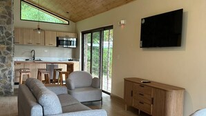 A modern living room with a sofa, armchairs, a coffee table, and a TV. - Mountain View Fully Equipped Villa (El Valle de Antón)