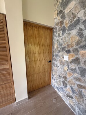 Una puerta de madera, un muro de piedra y un suelo de madera.