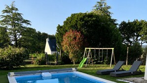 Una piscina rectangular con superficie de agua azul cristalina, rodeada por un borde de baldosas blancas.