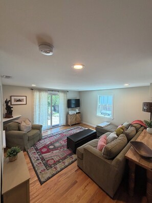 A living room with a sofa, a coffee table, a television, and a patterned rug. - Large 3+bdr, 2 bth, Boulder Retreat: Hot Tub, Flatiron Views & Close to downtown (Boulder)